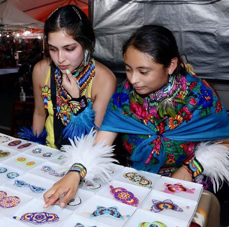 A pair of participants look over items in the vendors tent.